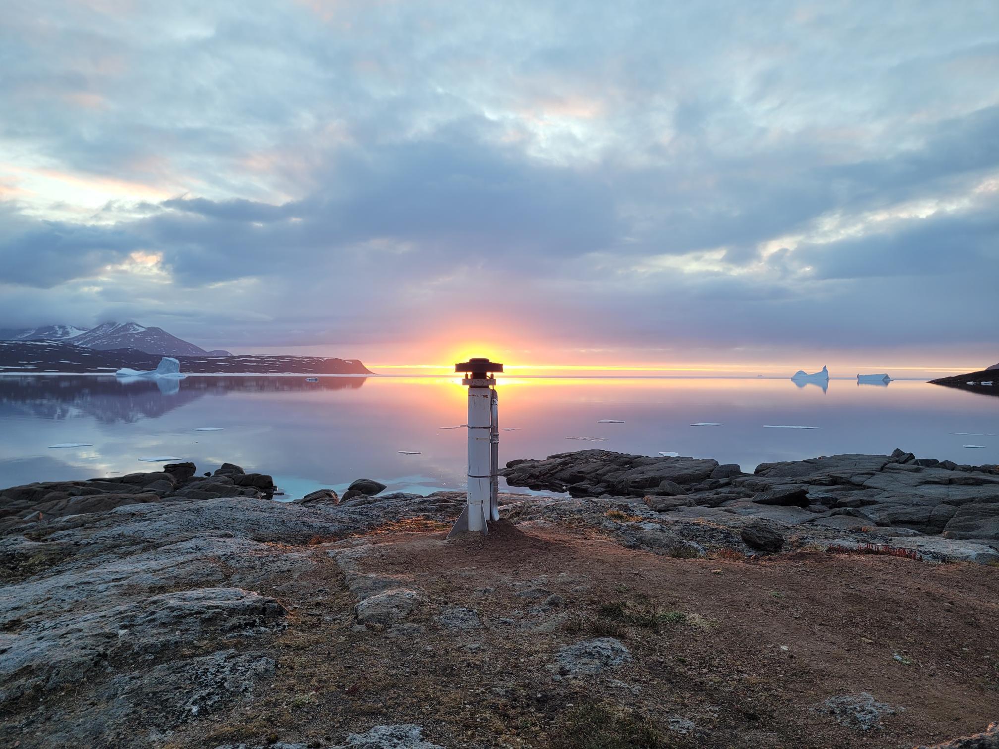 Un paysage côtier nordique avec un repère géodésique, représentatif de l’infrastructure des LGC utilisée pour faciliter le positionnement de précision.